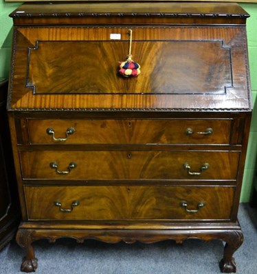 Lot 1382 - An early 20th century mahogany veneered bureau on claw and ball feet