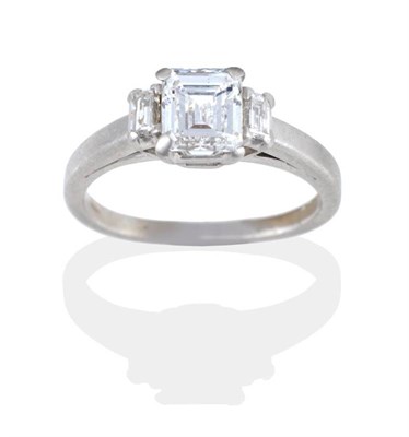 Lot 176 - A Three Stone Diamond Ring, an octagonal cut diamond in a claw setting, spaced by baguette cut...