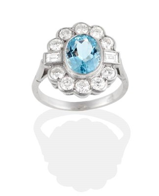 Lot 179 - An Aquamarine and Diamond Cluster Ring, an oval cut aquamarine in a rubbed over setting within...