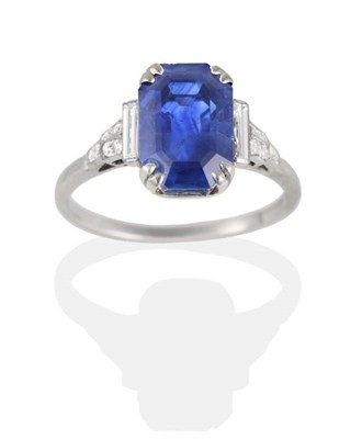 Lot 185 - An Art Deco Sapphire and Diamond Ring, an octagonal cut sapphire in a claw setting, spaced by...