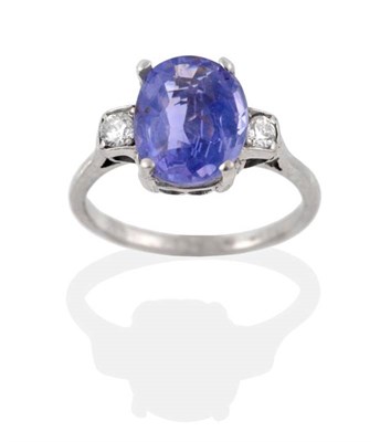 Lot 212 - A Sapphire and Diamond Three Stone Ring, an oval cut sapphire in a claw setting, spaced by...