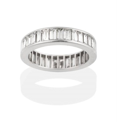 Lot 231 - A Baguette Cut Diamond Eternity Ring, channel set to a flat-sided shank, total estimated...