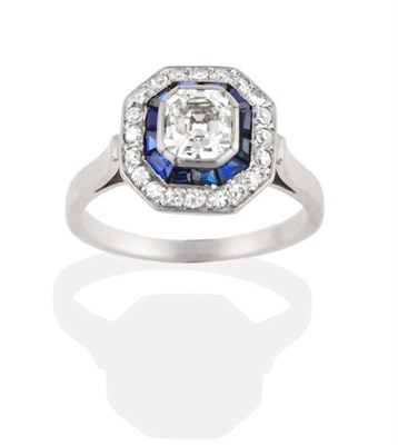 Lot 235 - A French Art Deco Diamond and Sapphire Cluster Ring, an asscher cut diamond in a rubbed over...