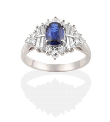 Lot 247 - A Sapphire and Diamond Cluster Ring, an oval cut sapphire in a claw setting within a lozenge-shaped