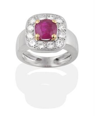 Lot 251 - A Ruby and Diamond Cluster Ring, a cushion cut ruby in a claw setting within a conforming border of