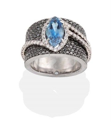 Lot 254 - An Aquamarine and Black and White Diamond Ring, a marquise cut aquamarine in a claw setting, within