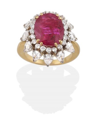 Lot 268 - A Ruby and Diamond Cluster Ring, an oval cut ruby in a claw setting within a border of round...