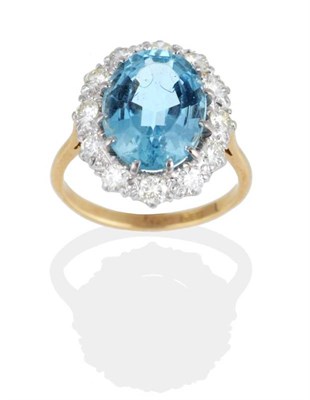Lot 289 - An Aquamarine and Diamond Cluster Ring, an oval cut aquamarine in a claw setting, within a...