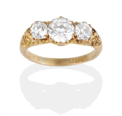 Lot 293 - An 18 Carat Gold Diamond Three Stone Ring, graduated old cut diamonds in a carved setting,...