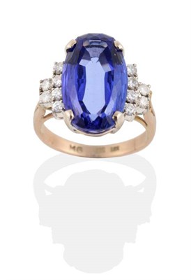 Lot 300 - A Tanzanite and Diamond Ring, an oval cut tanzanite in a claw setting, to stepped diamond set...