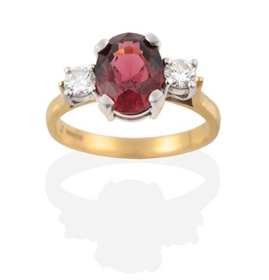 Lot 311 - An 18 Carat Gold Garnet and Diamond Three Stone Ring, an oval cut garnet spaced by round...