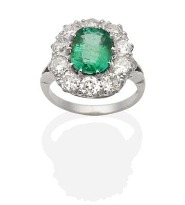 Lot 351 - An Emerald and Diamond Cluster Ring, a cushion cut emerald within a border of old cut diamonds...