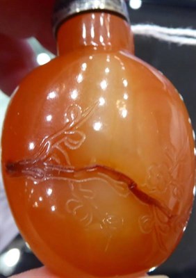 Lot 365 - A Chinese Carnelian Snuff Bottle, of ovoid form, engraved with scrolling foliage, with silver...