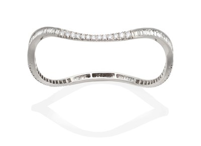 Lot 361 - A Diamond Bangle, an undulating band of round brilliant cut and tapered baguette cut diamonds,...