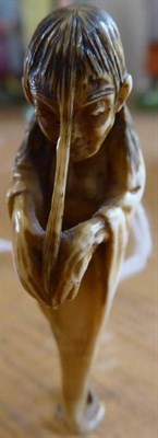 Lot 386 - A Japanese Ivory Okimono, Meiji period, as a seated wolf with a severed head at its feet, 4.5cm...