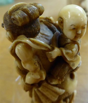 Lot 387 - A Japanese Ivory Netsuke, Edo/Meiji period, as a Nio running carrying a child on his back, 7cm high