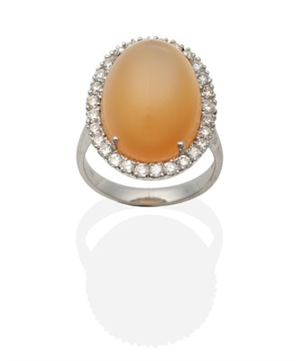 Lot 431 - An 18 Carat White Gold Moonstone and Diamond Cluster Ring, an oval peach-coloured moonstone in...