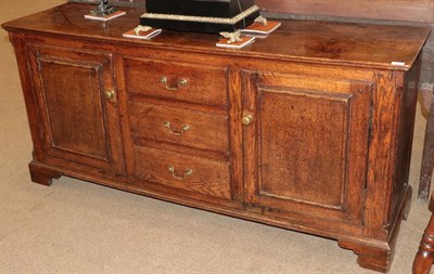 Lot 491 - A Mid 18th Century Enclosed Oak Dresser, with a central bank of three drawers flanked by...