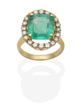 Lot 435 - An Emerald and Diamond Cluster Ring, an octagonal cut emerald in a claw setting, within a halo...