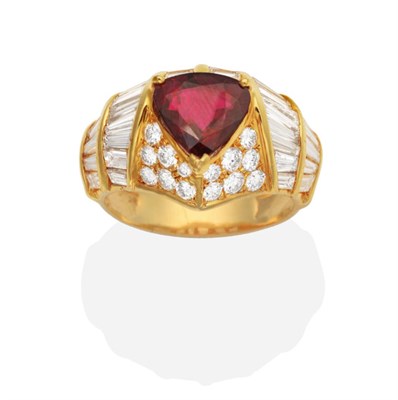 Lot 441 - A Ruby and Diamond Ring, a trilliant cut ruby in a claw setting to broad shank channel set with...