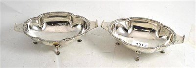 Lot 121 - A pair of silver dishes on hoof feet with shaped edges and lipped handles, Sheffield 1933