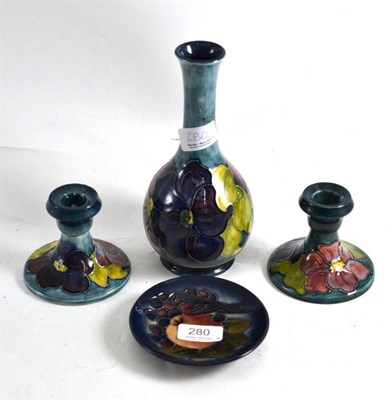 Lot 280 - A Walter Moorcroft Clematis vase, a pair of squat candlesticks and a Moorcroft Finches dish (4)