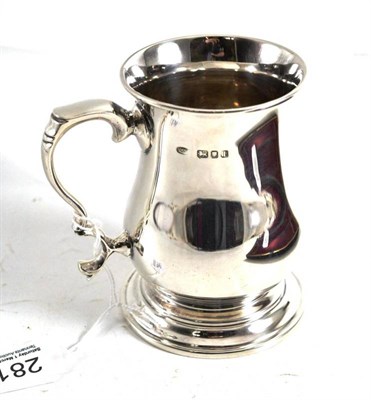 Lot 281 - A silver mug in the George III style, with double scroll handle, London 1944