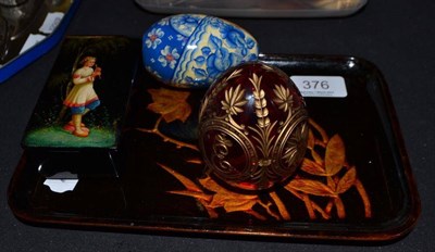 Lot 376 - A Russian cut ruby glass egg, a papier mache box, a tray and another egg