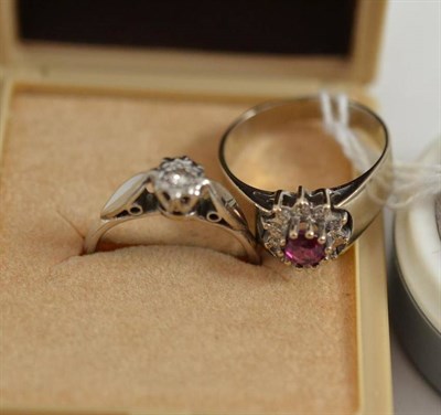 Lot 12 - An 18ct white gold ruby and diamond cluster ring and a diamond solitaire ring (2)