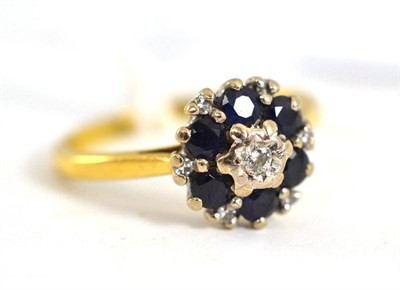 Lot 29 - A diamond and sapphire cluster ring, stamped '18CT'