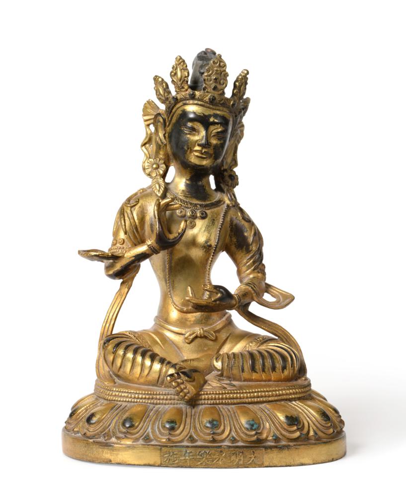 Lot 147 - A Chinese Gilt Bronze Figure of Buddha, Yongle reign mark, seated wearing a scroll headdress on...