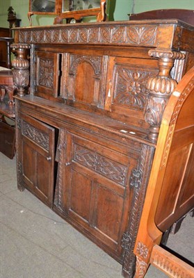 Lot 499 - A reproduction oak court cupboard with carved frieze and panelled doors