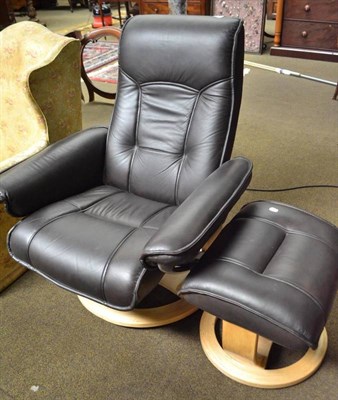 Lot 531 - Modern swivel armchair and matching stool in brown leatherette