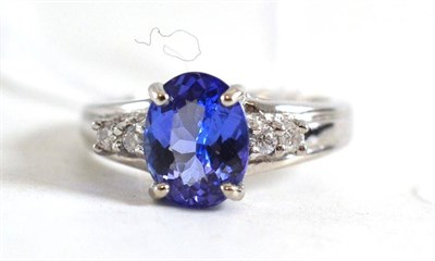 Lot 60 - An 18ct white gold tanzanite and diamond ring, the oval mixed cut tanzanite with two round...