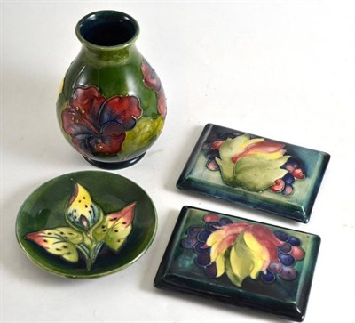Lot 138 - A Walter Moorcroft Hibiscus pattern vase, 14cm high; two Walter Moorcroft Leaf and berry...