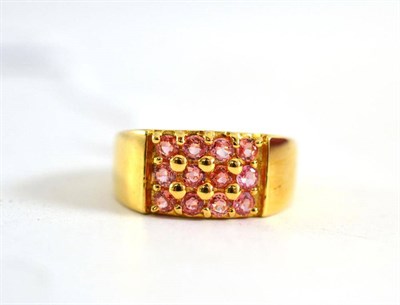 Lot 151 - An 18ct gold padparadscha grid ring, twelve round mixed cut pinky-orange sapphires in yellow...