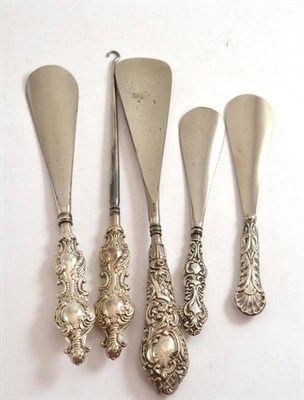 Lot 237 - A silver handled button hook and four silver handled shoehorns