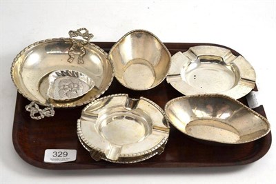 Lot 329 - A collection of silver including a bowl with ribbon handles, three ash trays, two pin dishes etc