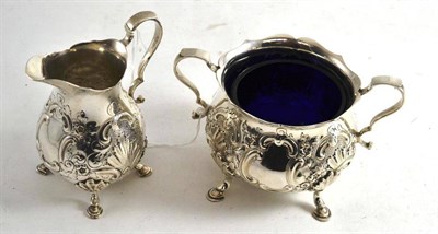 Lot 391 - A silver cream and sugar with blue glass liner