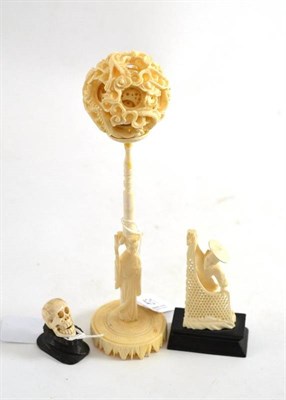 Lot 431 - Carved ivory puzzle ball on stand, carved ivory skull and a carved figure, all late early 20th...