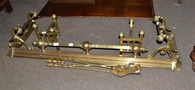 Lot 597 - A Victorian brass fender, a set of three brass fire irons and a pair of brass andirons