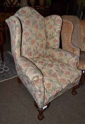 Lot 637 - Late 19th/early 20th century wing back chair recovered in beige and floral fabric