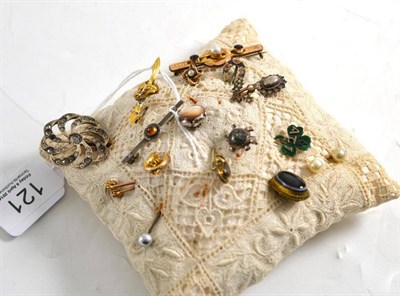 Lot 121 - A collection of stick pins and bar brooches pinned to a small cushion