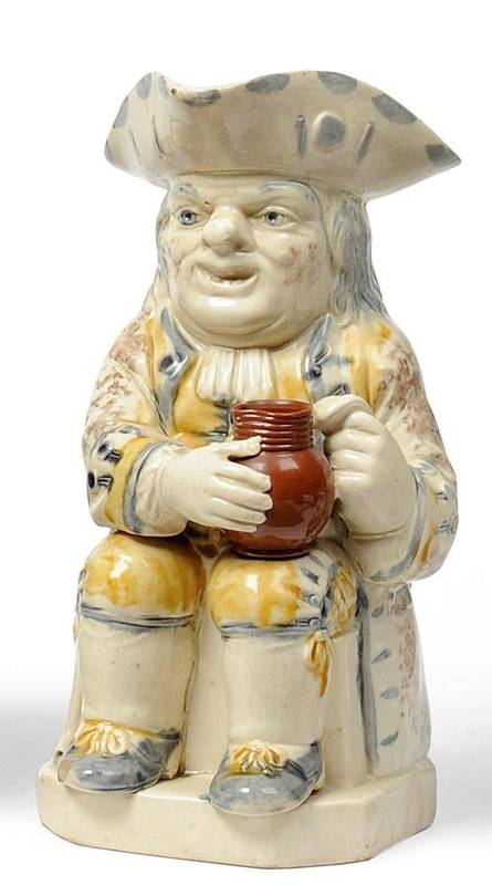 Lot 24 - A Staffordshire Pottery Toby Jug, late 18th century, the seated figure with blue spotted hat, brown