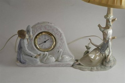 Lot 9 - A Lladro figural lamp base modelled as a young lady beside a tree and a figural clock