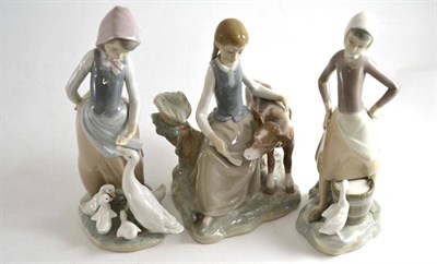 Lot 14 - Three Lladro figures comprising girl with ducks, girl with a pale of milk and a lady comforting...