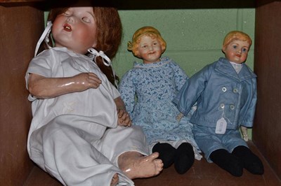 Lot 100 - Two painted bisque socket head shoulder dolls, fully clothed and a bisque socket head doll...