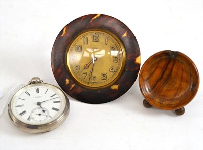 Lot 139 - A faux tortoiseshell travel timepiece, fob watch stand and a silver pocket watch