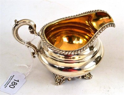 Lot 180 - A Victorian silver cream jug with a gadrooned border and four scrolled feet, London 1839