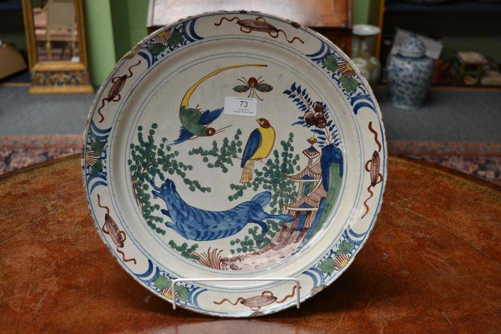 Lot 73 - A Dutch Delft Charger, mid 18th century, painted in blue, green, manganese and ochre with a...